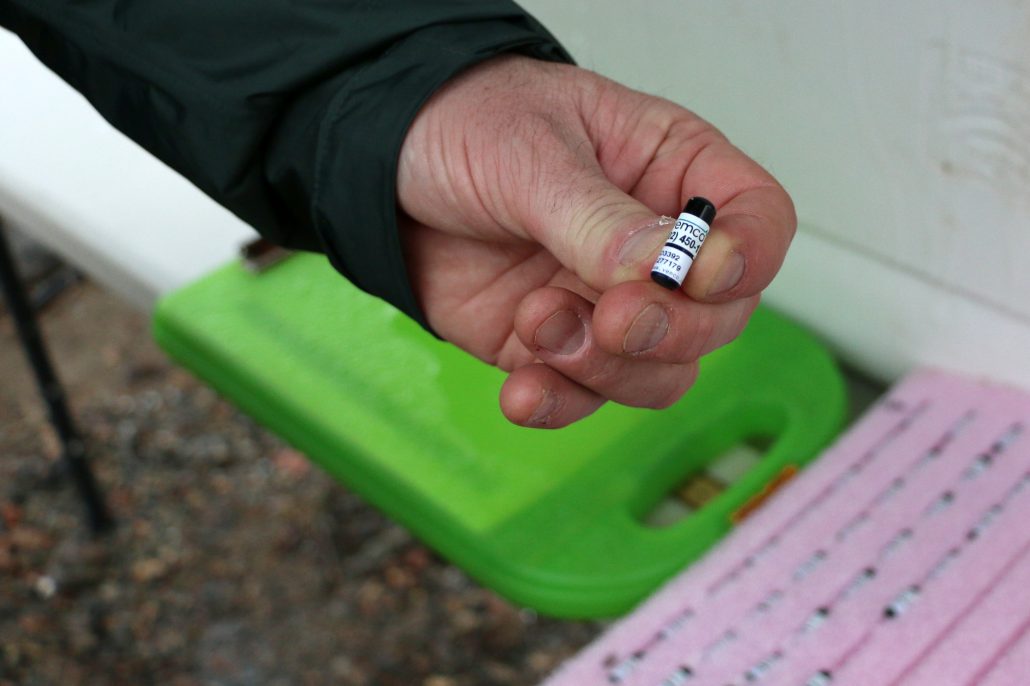 An acoustic tag about the size of a jelly bean held in someone's hand