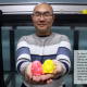 Dixia Fan, PhD, holding two 3D printed penguins, the Guardians of the Intelligent Towing Tank, which he is standing in front of